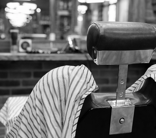 Bulanık siyah beyaz arka planda klasik bir bakım salonunda boş vintage berber koltuğu.